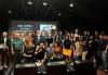 SAG-AFTRA members and independent filmmakers at the September 2024 Low-Budget Contracts presentation. Photo by Rhonda Laizer. A large group of about 30 people pose together in a dimly lit theater space, smiling for the photo. Behind them, a screen displays a presentation titled "SAG-AFTRA Low Budget Entertainment Contracts." The group includes men and women of various ages and ethnicities, some in casual wear and others in business attire.